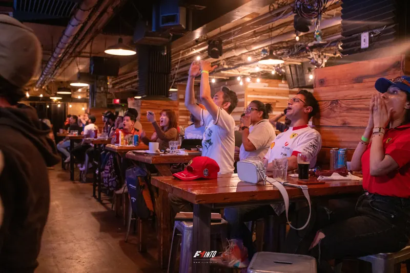 Fans out of their seats with their arms up at the Monaco Grand Prix