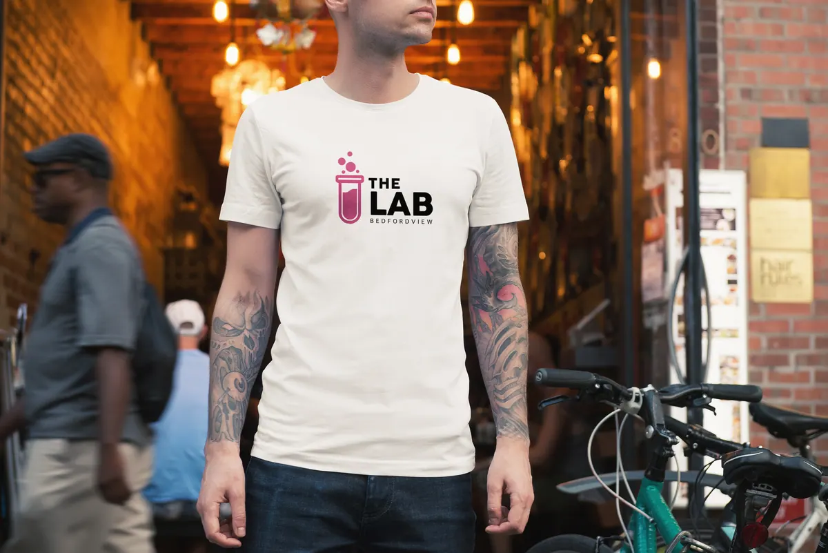Man in a white The Lab T-shirt on a city street