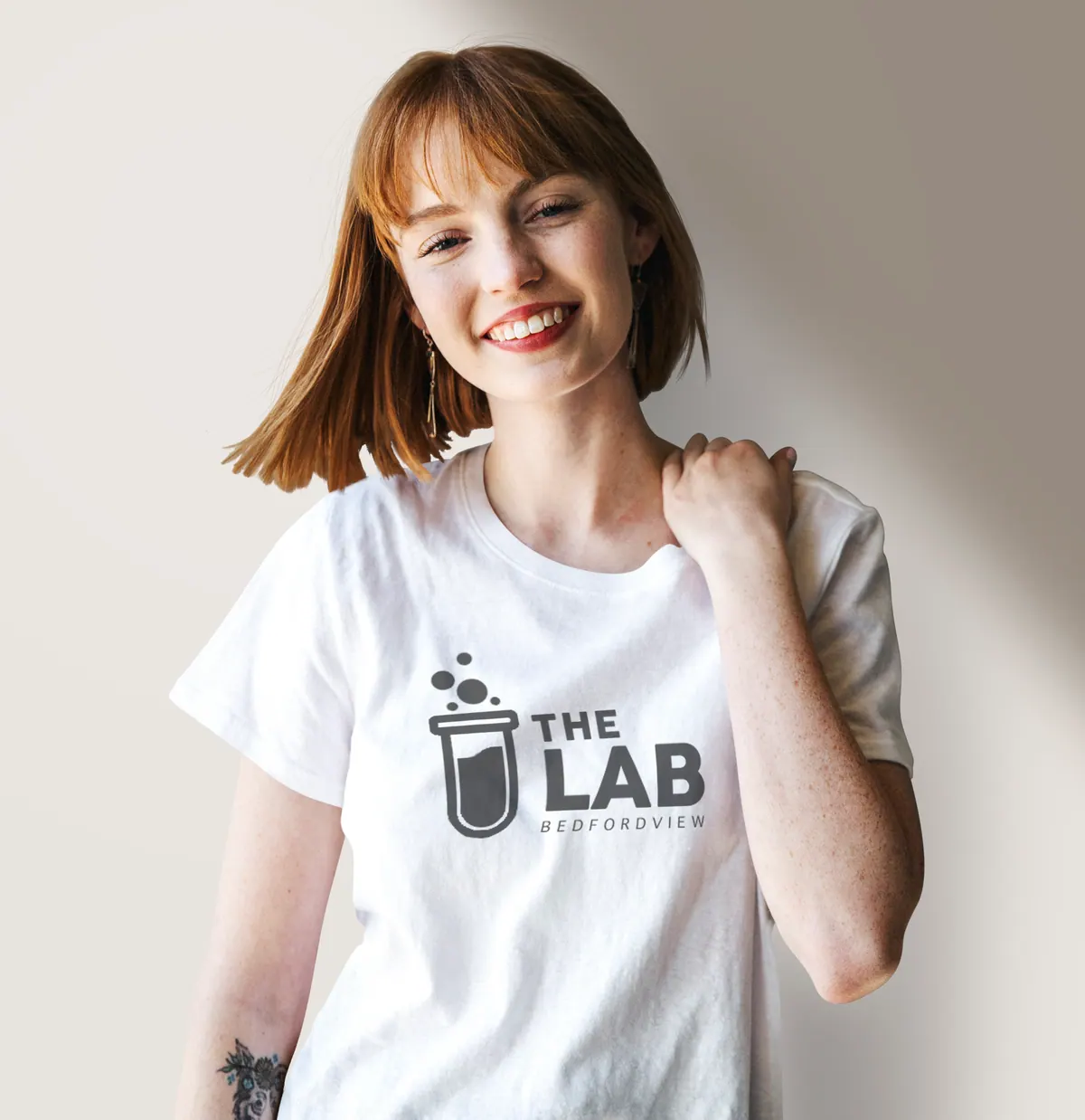 Smiling woman in a white The Lab T-shirt