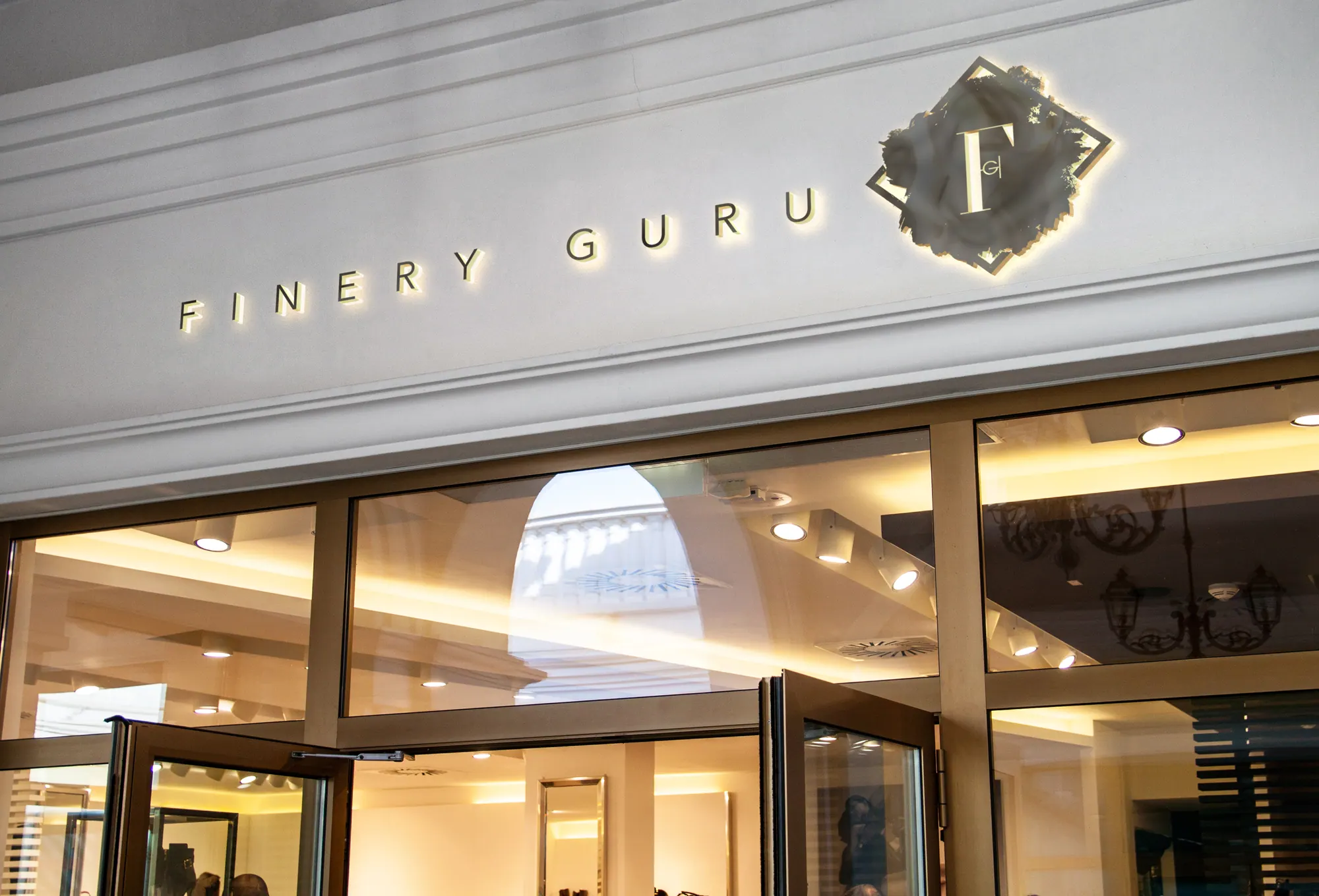 Finery Guru storefront with illuminated gold and black signage