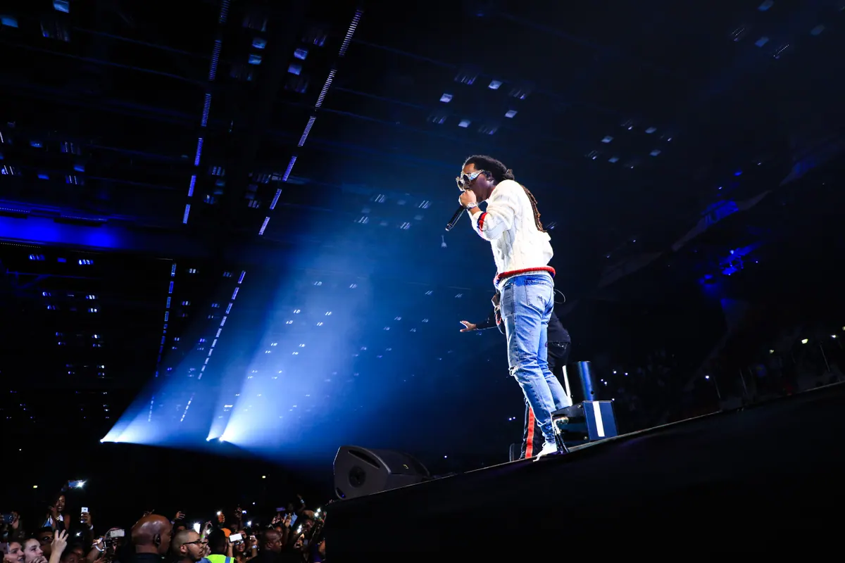Migos performing under blue light on the South African tour