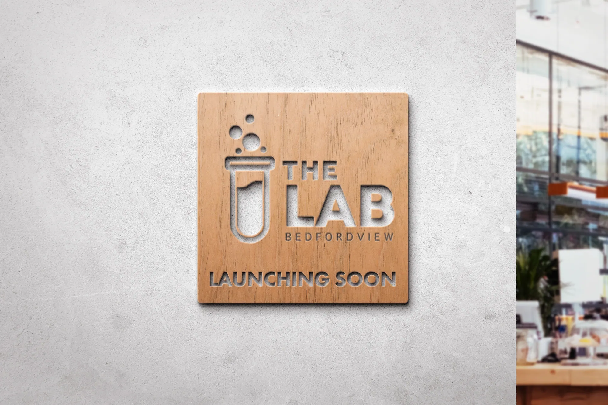 Wooden The Lab Launching Soon sign on a concrete wall