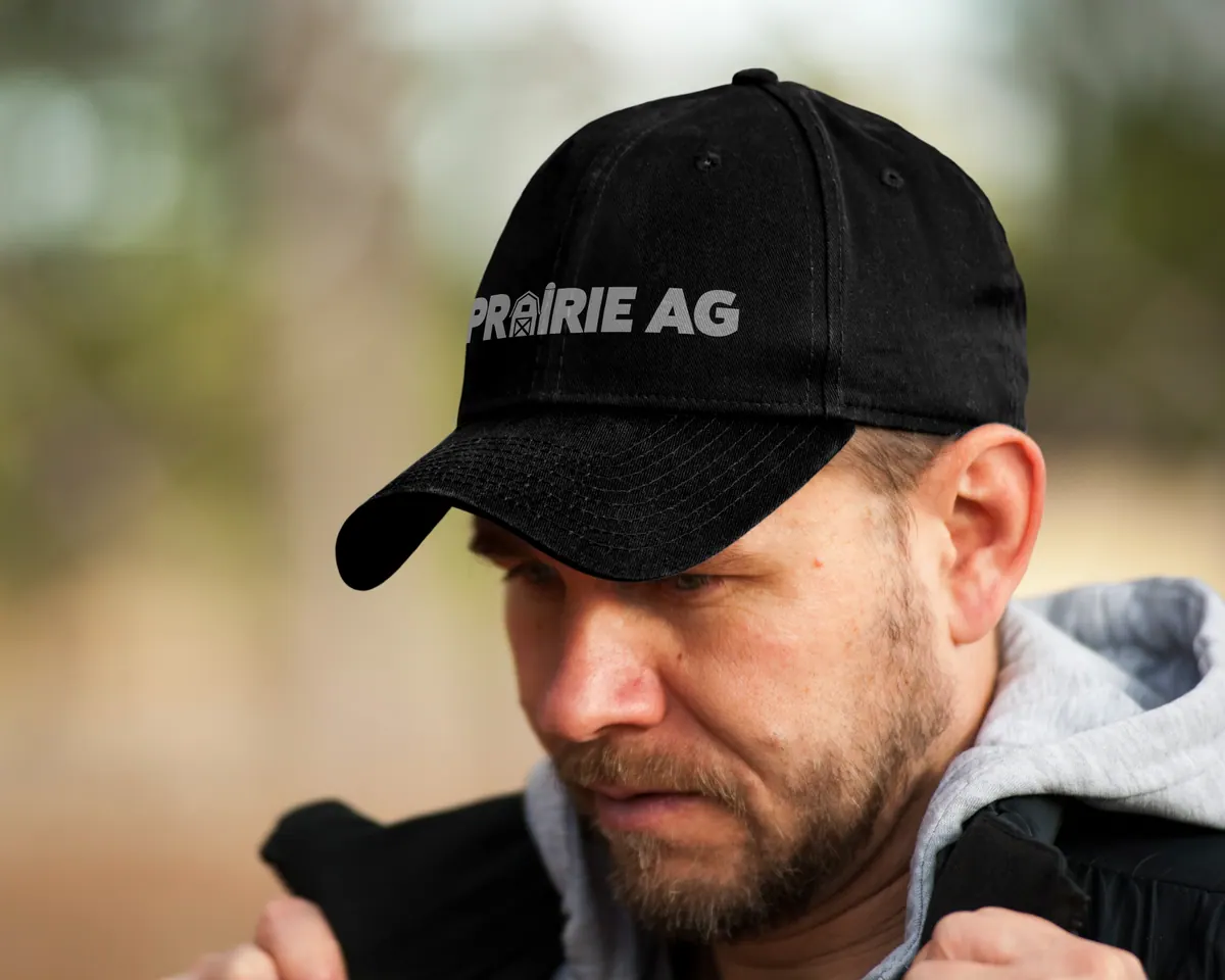 Man wearing a black Prairie Ag cap