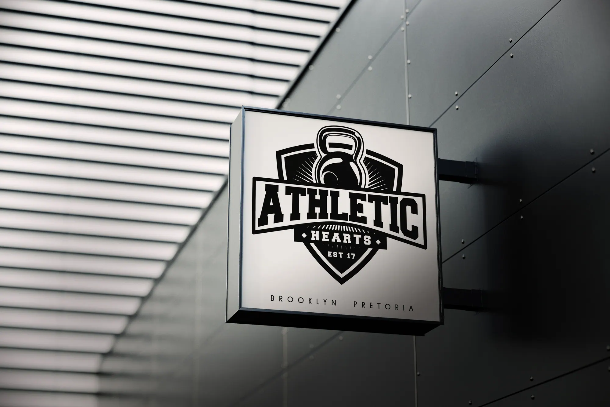 Athletic Hearts kettlebell shield logo on a wall-mounted sign