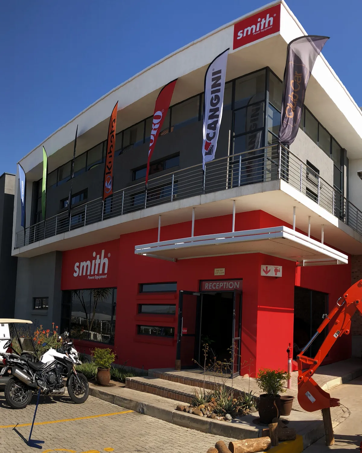 The Smith Power Equipment head office: the red Smith facade under brand flags for Kubota, Toro, Cangini and Club Car